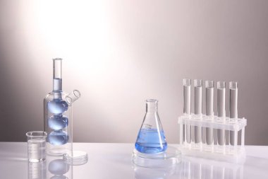 Laboratuvar analizi. Aydınlık arkaplan karşısında farklı cam eşyalar