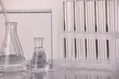 Laboratuvar analizi. Cam mataralar ve karıştırıcı çubuklar beyaz masada, metin için boşluk