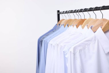 Kuru temizleme servisi. Beyaz arkaplanda asılı bir sürü farklı kıyafet, metin için boşluk