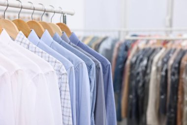 Kuru temizleme servisi. İçerde askıda asılı bir sürü farklı kıyafet var.