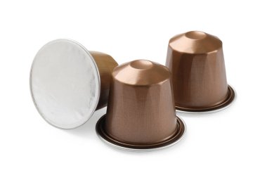 Beyaz üzerine izole edilmiş üç plastik kahve kapsülü.