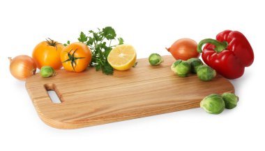 Tahta kesme tahtası ve beyaz üzerine izole edilmiş taze sebzeler.