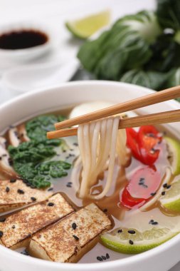 Yemek çubuklarıyla lezzetli vejetaryen ramen yemek, yakın plan.