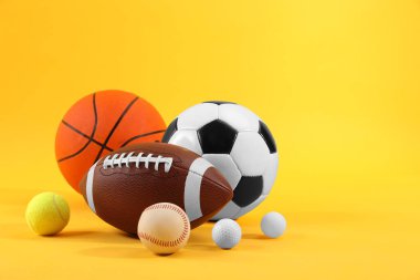 Sarı arkaplanda çok farklı spor topları, metin için boşluk