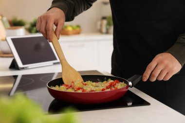 Mutfağın tepesinde yemek pişiren adam, yakın plan.