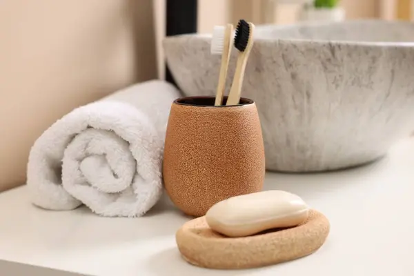 Different bath accessories and personal care products near sink on bathroom vanity, closeup