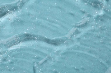 Açık mavi arkaplanda kozmetik serumu temizle, makro görünüm