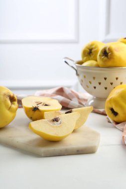 Lezzetli quinces ve beyaz ahşap masa üzerinde metal kevgir