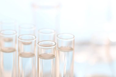 Laboratuvar analizi. Bulanık arkaplan üzerinde birçok cam test tüpü, metin için yakın çekim ve boşluk