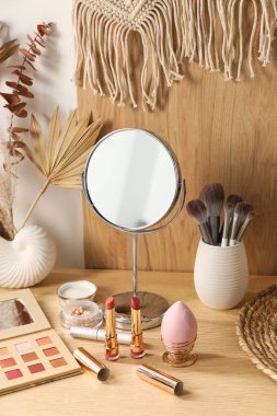 Aynalı makyaj masası ve makyaj malzemeleri odada.