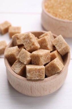 Kahverengi şeker küpleri beyaz masada, yakın plan.