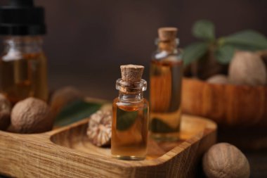 Nutmeg temel yağ ve fındıklar ahşap masada.