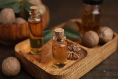 Nutmeg temel yağ ve fındıklar ahşap masada.