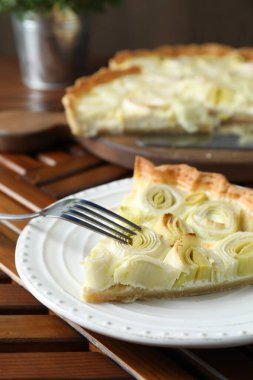 Tahta masada servis edilen lezzetli pırasa turtası.