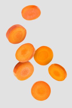 Açık gri arkaplana düşen taze havuç dilimleri