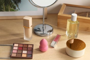 Makyaj malzemeleri ve parfüm ahşap tuvalet masasında.