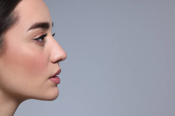 Portrait of beautiful young woman on grey background. Space for text