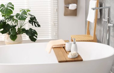 Banyodaki küvette farklı banyo aksesuarları ve sabunlar.