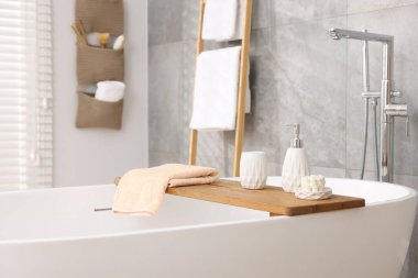 Banyodaki küvette farklı banyo aksesuarları ve sabunlar.