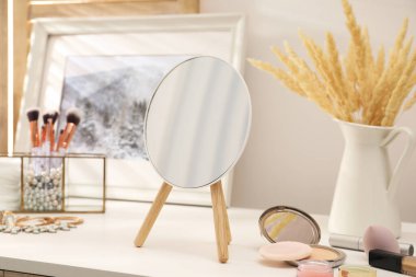 Makyaj odasında ayna, kozmetik ürünler ve mücevherlerle birlikte giyinme masası