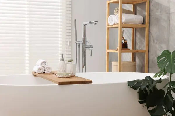 Different personal care products on bath tub in bathroom