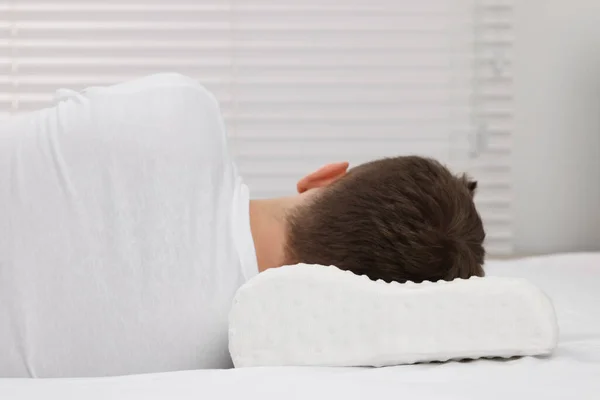 Man sleeping on orthopedic pillow at home
