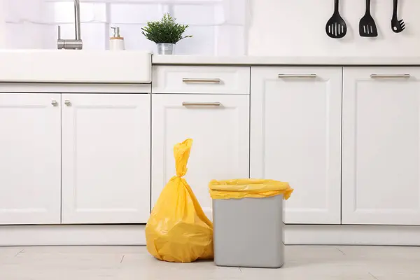Plastic garbage bag and trash can in kitchen
