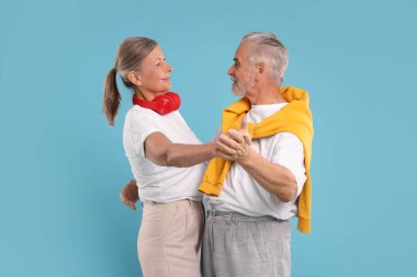 Üst düzey çift açık mavi arka planda dans ediyor.