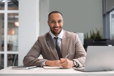 Ofisteki masada çalışan mutlu adam. Avukat, işadamı, muhasebeci ya da yönetici.