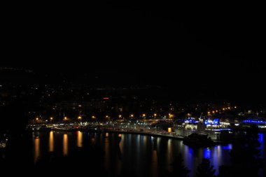 BÖLÜM, CROATIA - 08 Ekim 2023: Geceleyin liman ve binalarla aydınlatılmış şehrin güzel manzarası