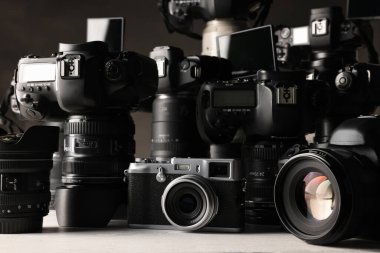 Beyaz ahşap masada modern kameralar, yakın plan.