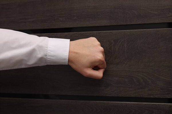 Collector knocking on door indoors, closeup view