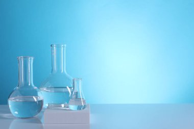 Laboratuvar analizi. Açık mavi arkaplanda cam mataralar, metin için boşluk