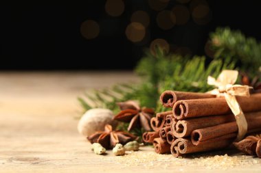 Ahşap masadaki farklı aromatik baharatlar siyah arka plana karşı, yakın plan. Metin için boşluk