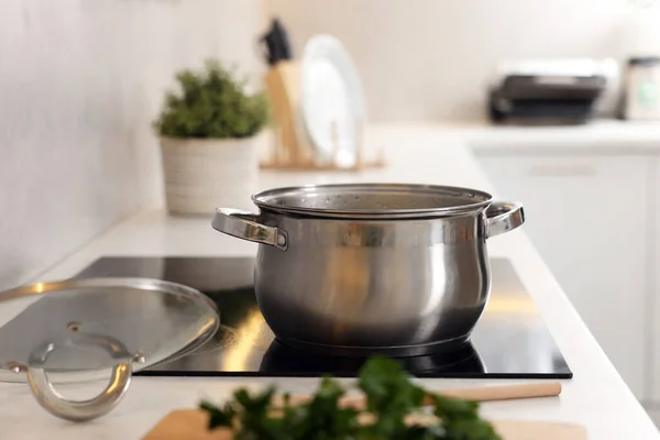 Pot with tasty soup on cooktop in kitchen