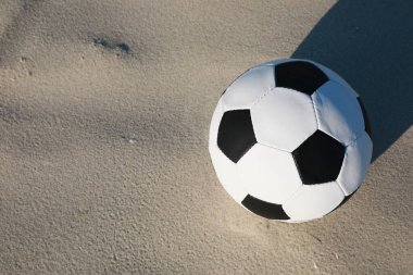 Futbol topu kumun üzerinde, yukarıdan bakınca yazı için yer var. Futbol ekipmanları