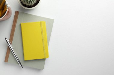 Düz kompozisyonda dizüstü bilgisayarlar ve beyaz masa üzerine kalem. Metin için boşluk