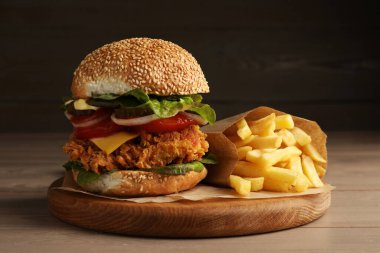 Çıtır tavuk köfteli leziz burger ve ahşap masada patates kızartması.