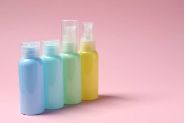 Pembe arka planda kozmetik seyahat kiti, mesaj için boşluk. Banyo aksesuarları