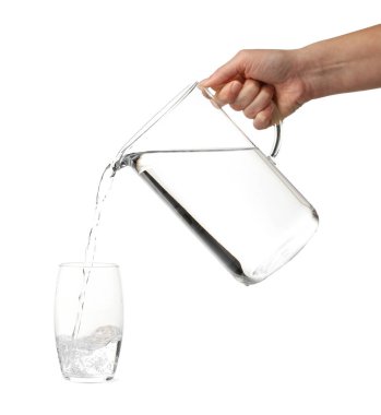 Kadın bardaktan bardağa beyaz arka planda su dolduruyor, yakın plan.