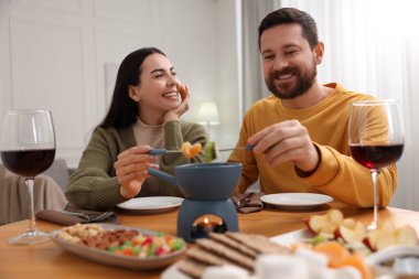 Sevgili çift evde romantik bir buluşmada fondü yiyor.