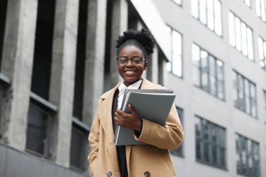 Dışarıda dosyaları olan mutlu bir kadın. Avukat, iş kadını, muhasebeci ya da müdür.