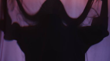 Mor kumaşın arkasındaki tüyler ürpertici hayalet silueti.