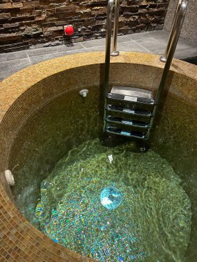 Otelde temiz su, tırabzan ve merdiven manzaralı lüks bir havuz.