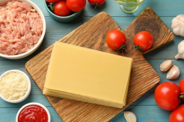 Lazanya malzemeleri mavi ahşap masada, düz yatıyordu.