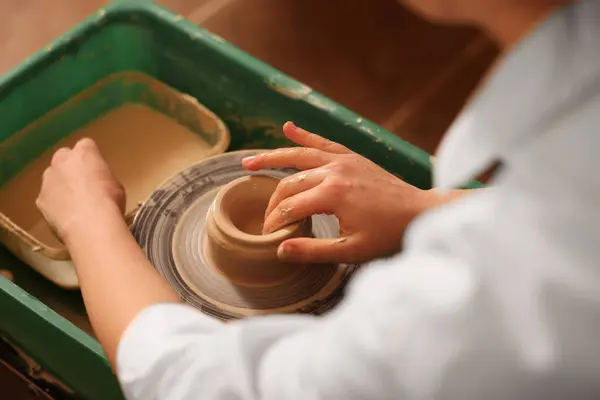 Clay crafting. Woman making bowl on potter's wheel, closeup
