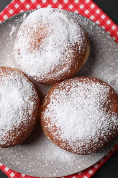 Delicious sweet buns with powdered sugar on table, top view