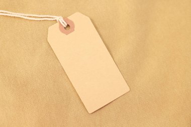 Bej giysili karton etiket, üst manzara. Metin için boşluk