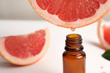 Masada meyve suyundan şişeye greyfurt suyu damlatıyor, yakın plan. Metin için boşluk