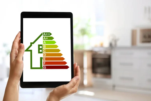 Energy efficiency. Woman using tablet with colorful rating on display indoors, closeup